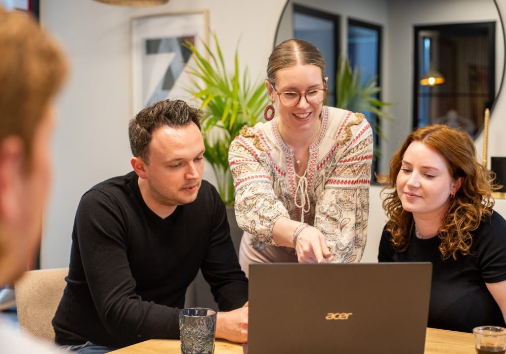 Collega's kijkend naar laptop